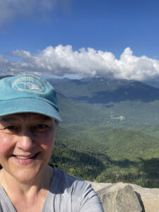 Photo of Rev. Lee on top of a mountain with green valley below