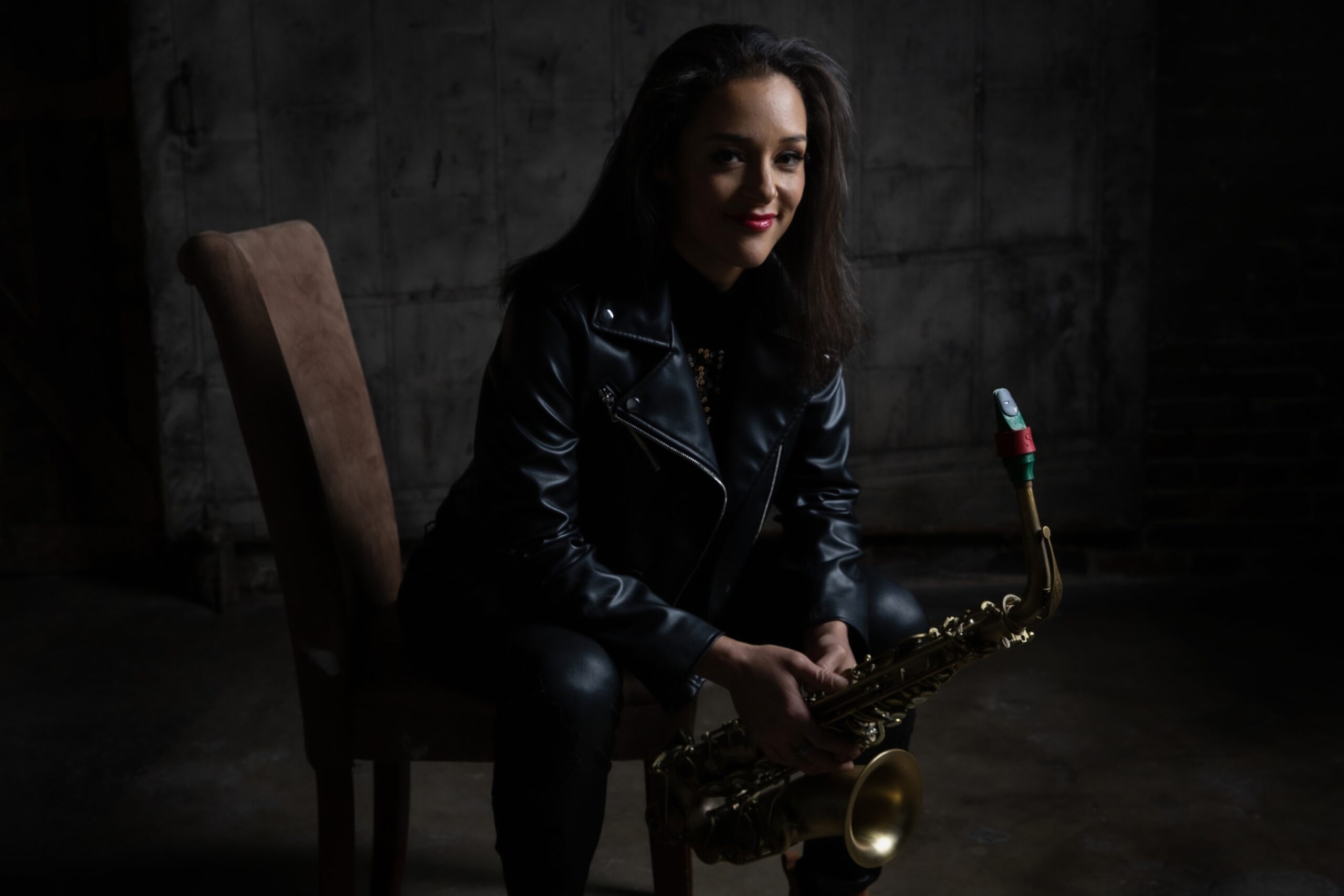 Photo of Vanessa Collier, seated holding her saxophone.