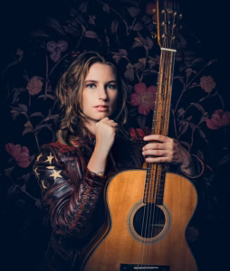 Photo of Jax holding her guitar